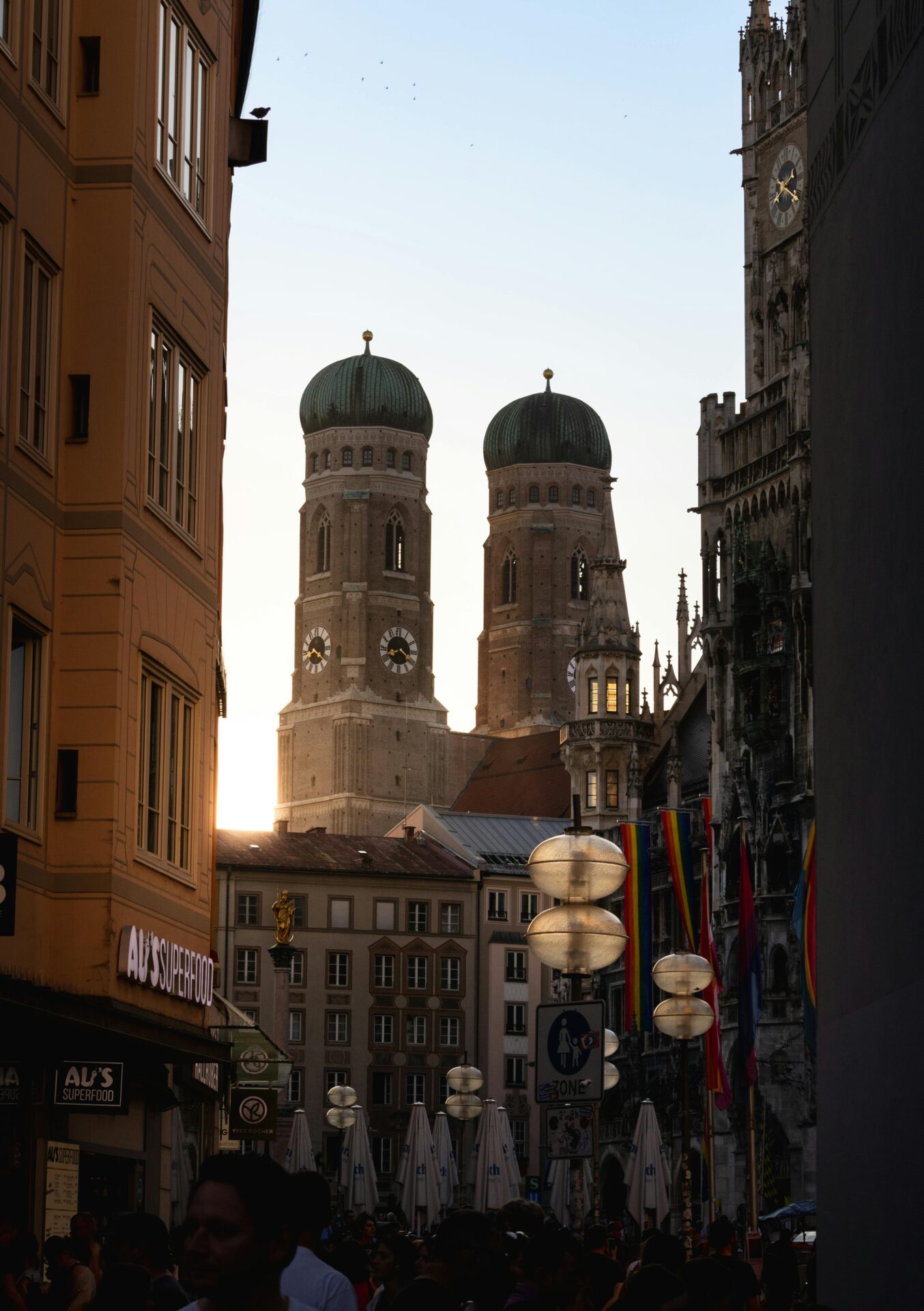 Münchner Fußgängerzone mit Kirchtürmen im Hintergrund.