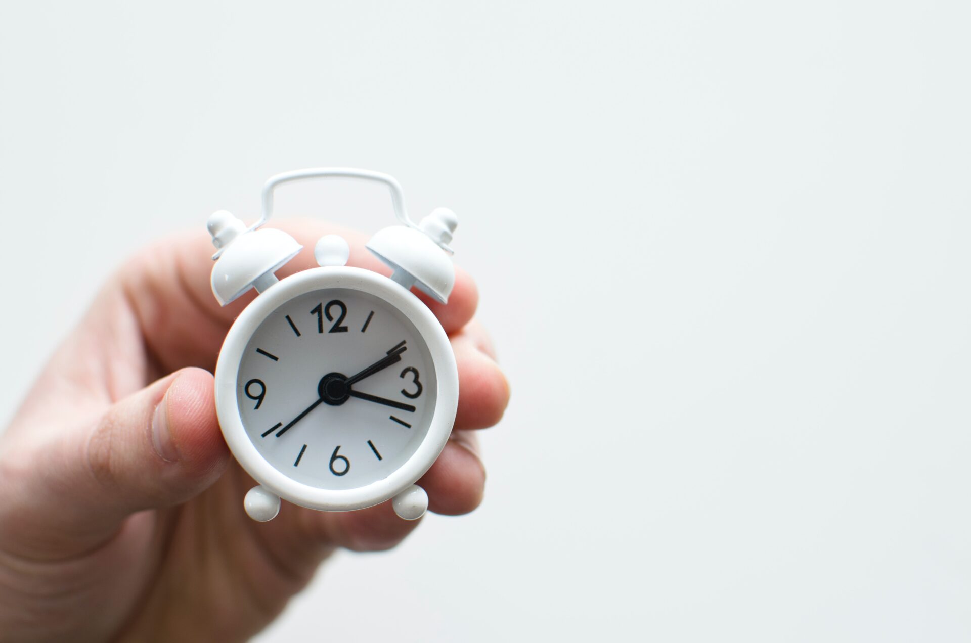 Eine Hand hält eine kleine Uhr